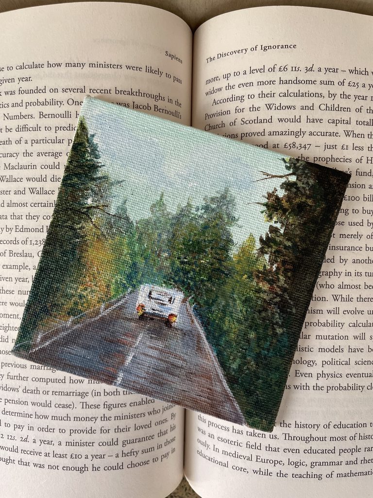 An original landscape painting by Shrestha Dutta, rendered in watercolour across the pages of an open book — a painter since childhood